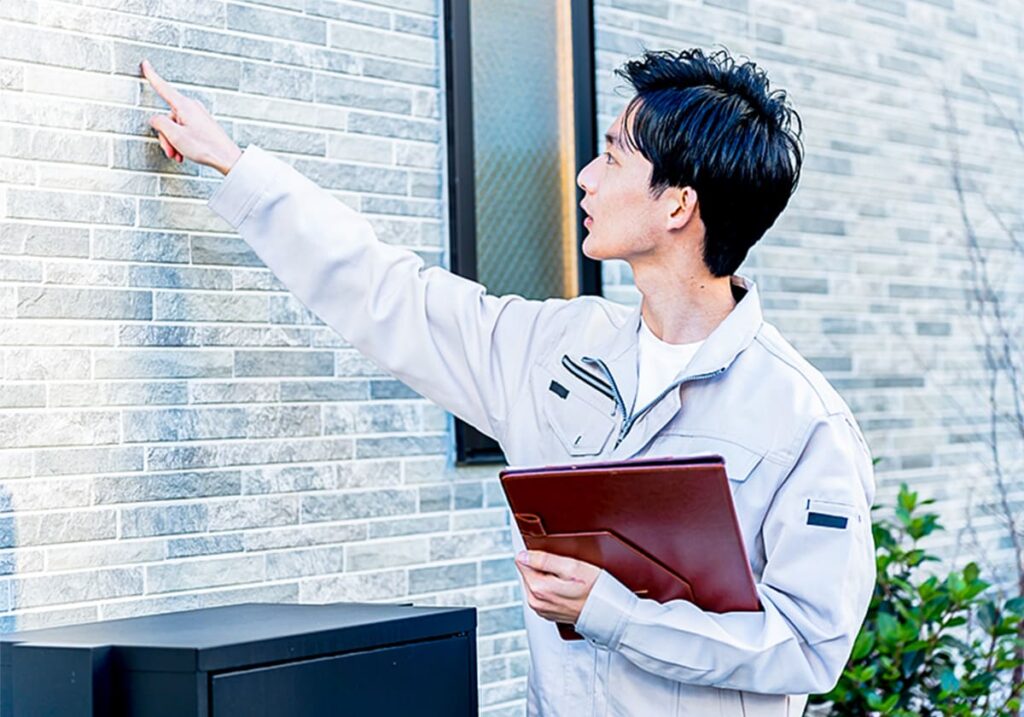 壁のチェックをしている男性